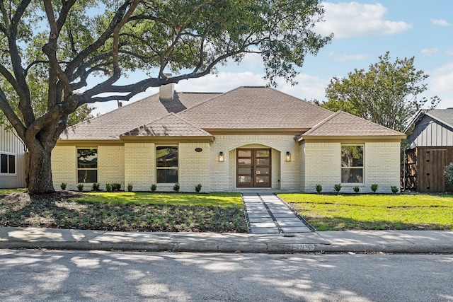 view of front of property with french doors and a front lawn