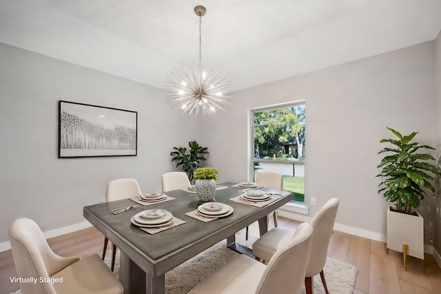 dining room with light hardwood / wood-style floors and a notable chandelier