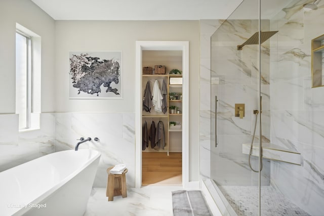 bathroom featuring tile walls, plus walk in shower, and wood-type flooring