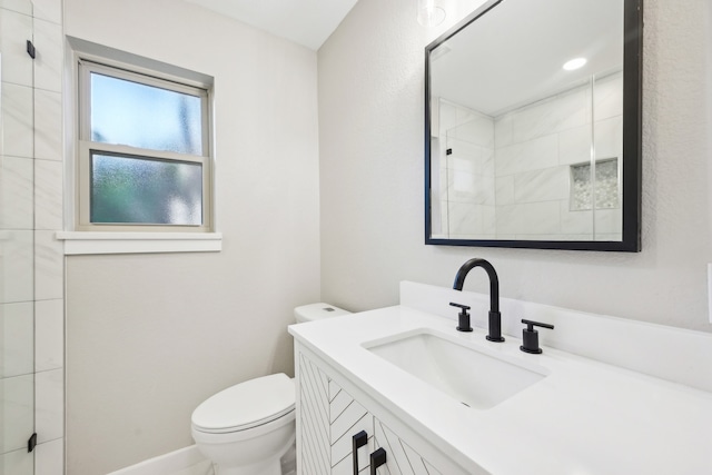 bathroom with vanity, toilet, and a shower with shower door