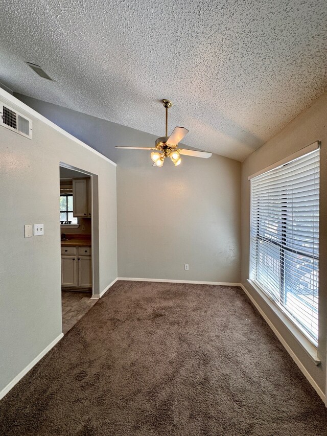 carpeted empty room featuring lofted ceiling, a textured ceiling, and ceiling fan