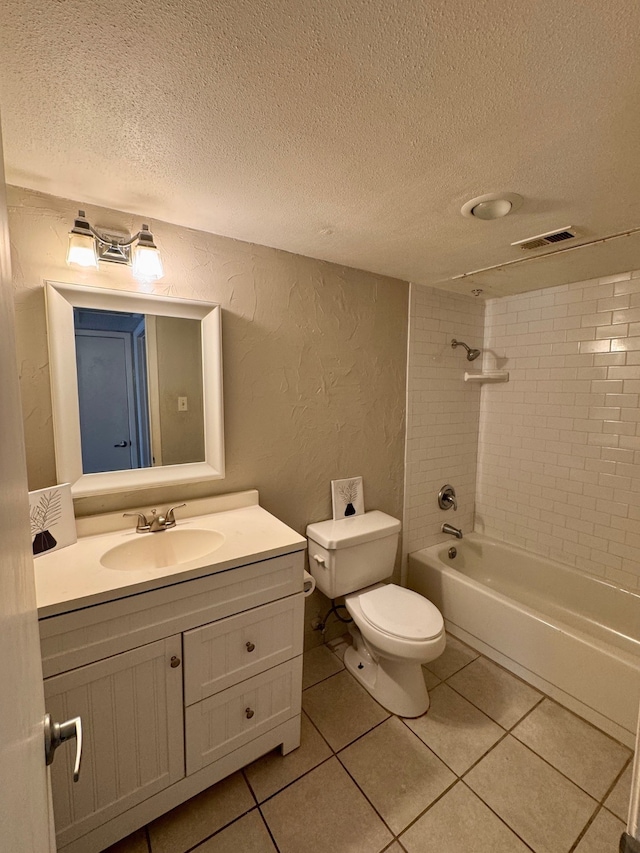 full bathroom with a textured ceiling, toilet, vanity, tiled shower / bath combo, and tile patterned flooring