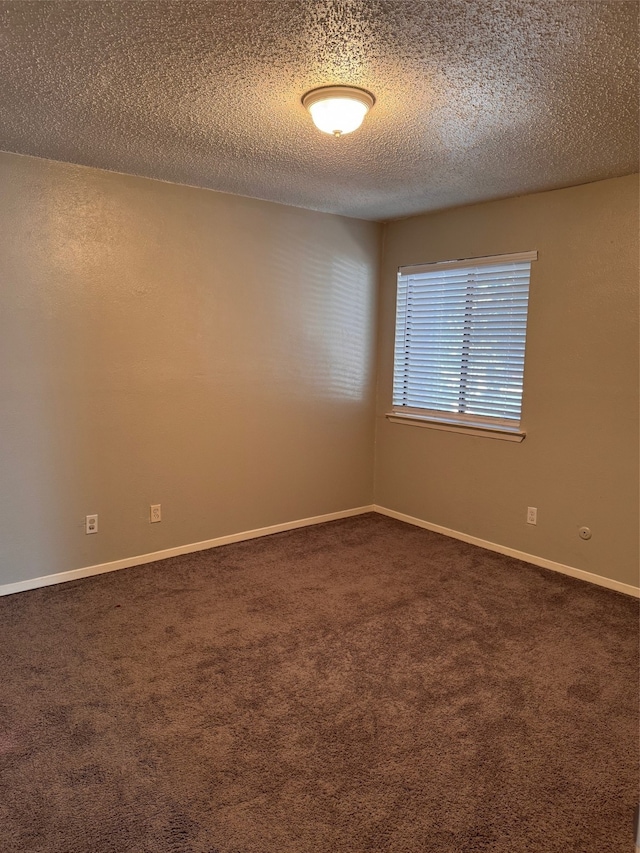 carpeted empty room featuring a textured ceiling