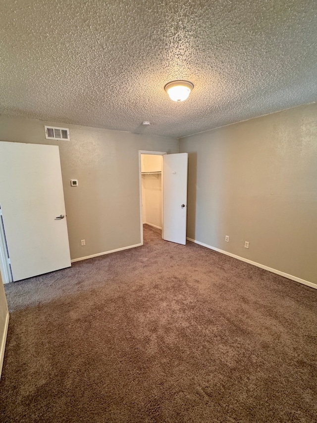 spare room with carpet flooring and a textured ceiling