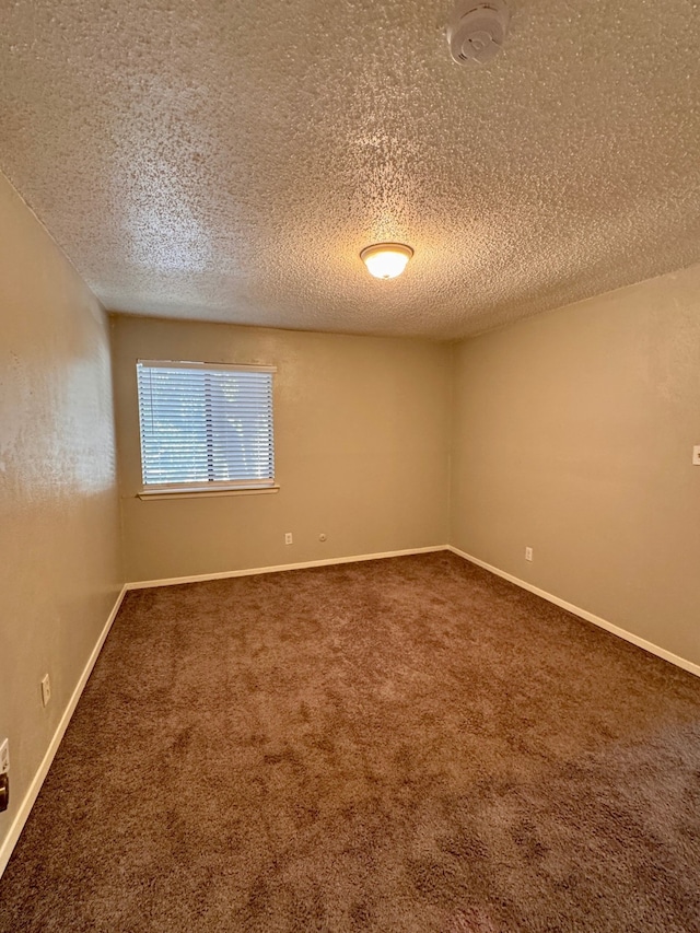 carpeted empty room with a textured ceiling