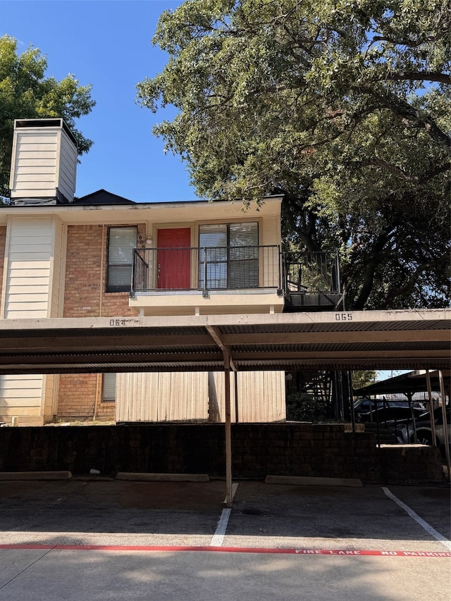 view of front of home featuring a balcony and a carport