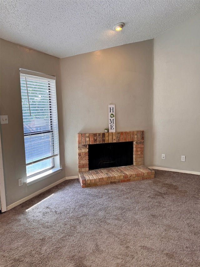 unfurnished living room featuring carpet flooring, a fireplace, a textured ceiling, and plenty of natural light