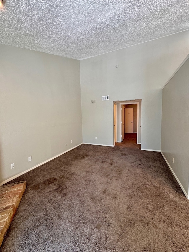 carpeted empty room featuring a textured ceiling