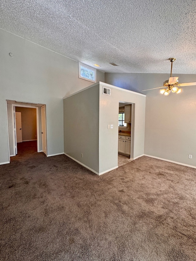 carpeted spare room featuring a textured ceiling, high vaulted ceiling, and ceiling fan