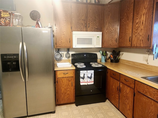 kitchen featuring black electric range oven and stainless steel fridge with ice dispenser