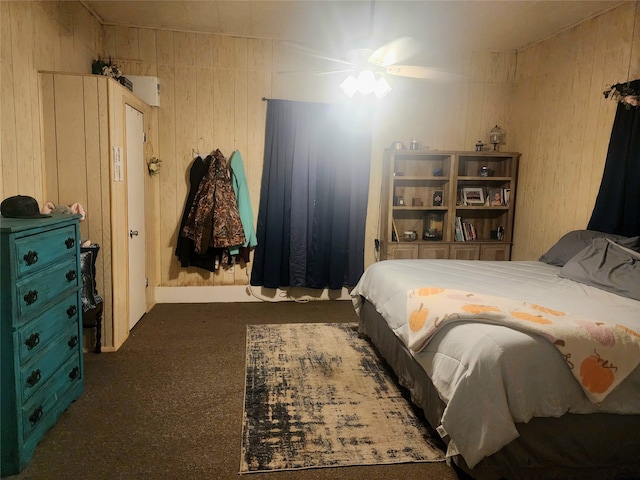 carpeted bedroom featuring wood walls and ceiling fan