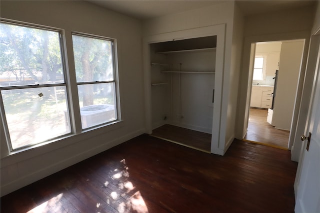 unfurnished bedroom featuring a closet and dark hardwood / wood-style floors