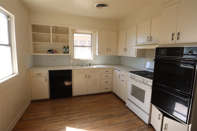 kitchen with sink, black appliances, white cabinetry, and hardwood / wood-style flooring