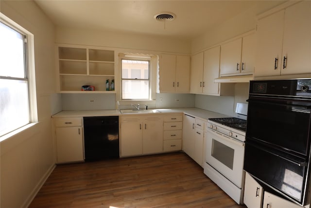 kitchen with sink, black appliances, white cabinetry, and dark wood-type flooring