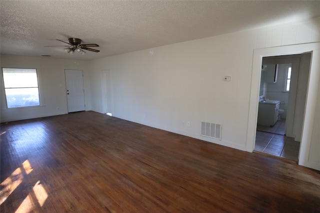 spare room featuring dark hardwood / wood-style floors, a textured ceiling, and ceiling fan