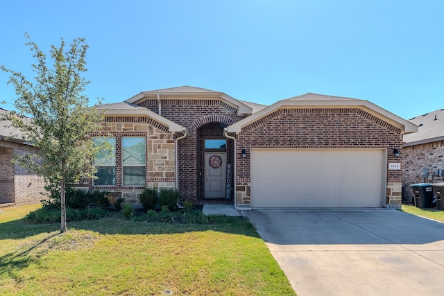 view of front of property featuring a garage and a front lawn