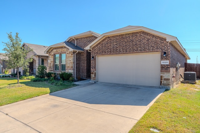 view of front of house with a garage, central AC, and a front yard