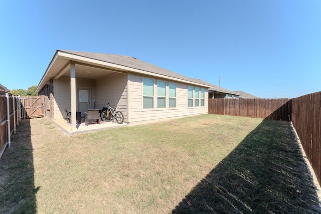 back of house featuring a patio area and a yard