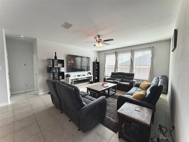 living room featuring light tile patterned floors, a textured ceiling, and ceiling fan