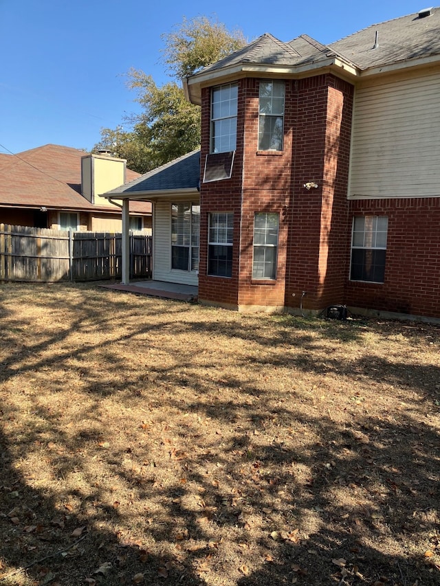 rear view of property featuring a lawn