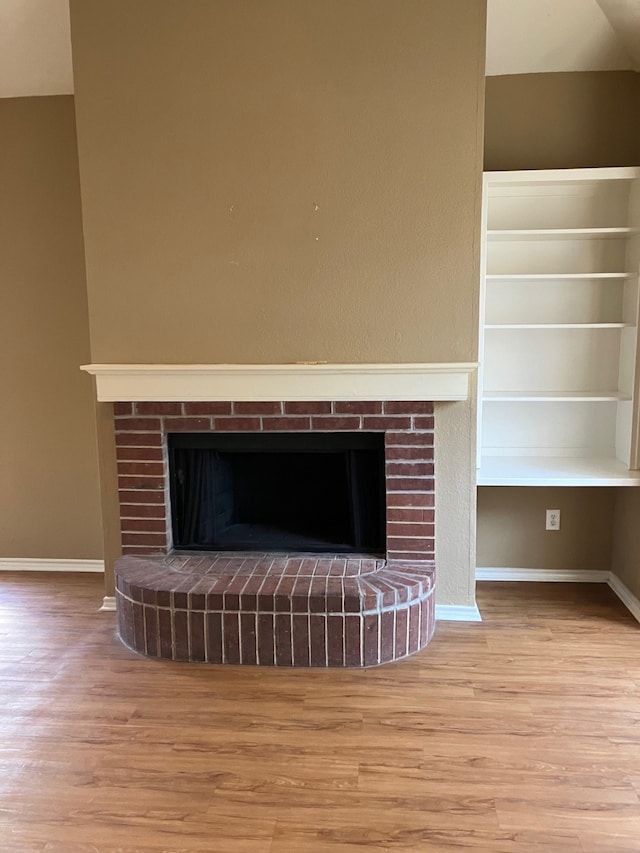 details featuring hardwood / wood-style flooring and a brick fireplace