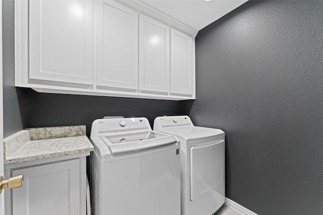 laundry room featuring independent washer and dryer and cabinets