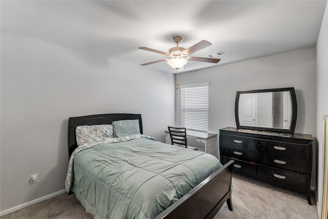 carpeted bedroom with ceiling fan and a textured ceiling