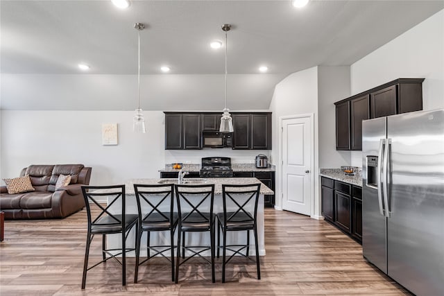 kitchen with a kitchen island with sink, light hardwood / wood-style floors, black appliances, and hanging light fixtures