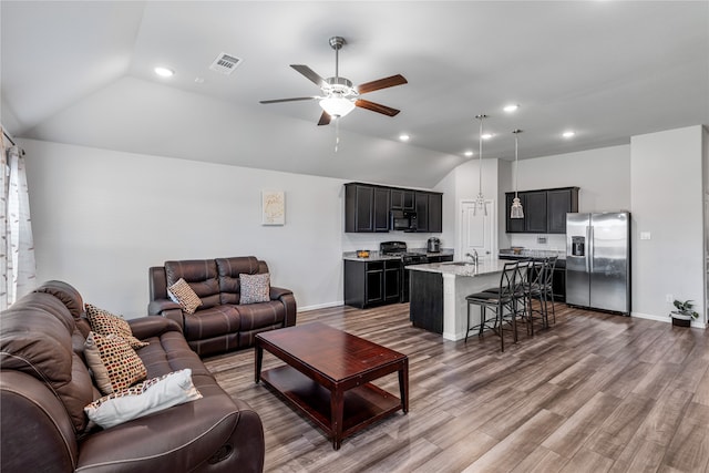 living room with sink, ceiling fan, lofted ceiling, and hardwood / wood-style floors