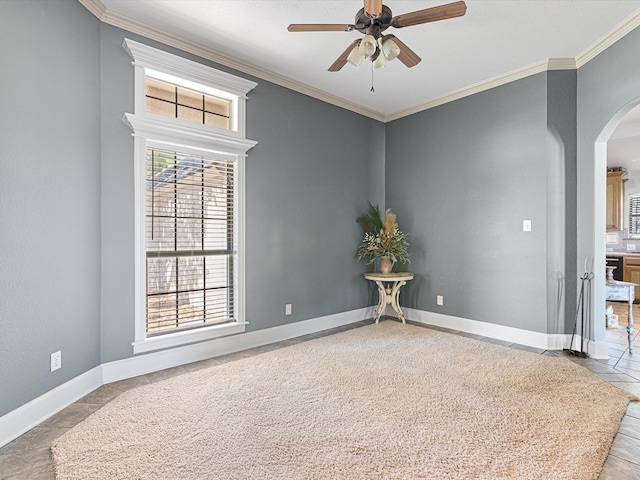 spare room with ceiling fan, ornamental molding, and light tile patterned floors