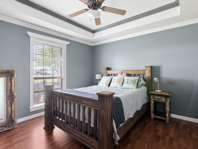 bedroom featuring dark hardwood / wood-style floors, a raised ceiling, ceiling fan, and crown molding