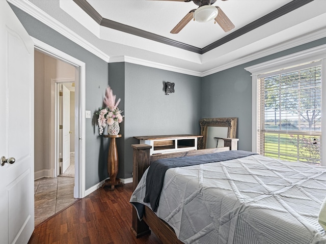 bedroom with dark hardwood / wood-style floors, ceiling fan, and ornamental molding