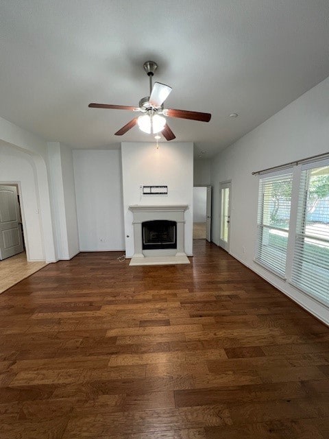 unfurnished living room featuring ceiling fan and dark hardwood / wood-style flooring