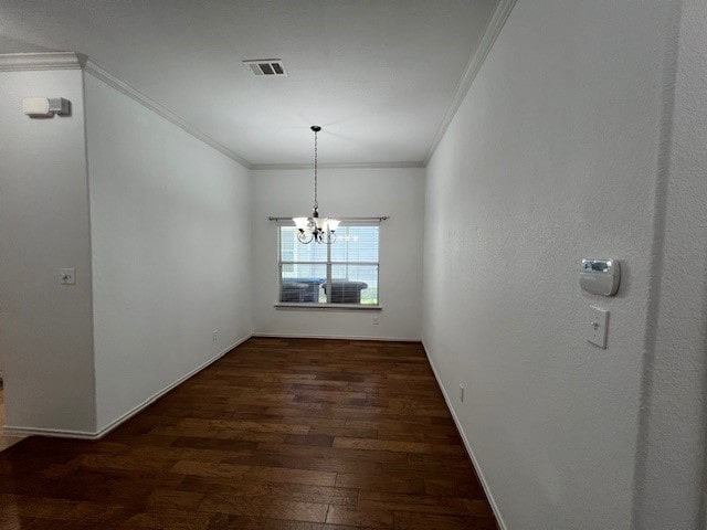 unfurnished dining area with ornamental molding, dark hardwood / wood-style flooring, and an inviting chandelier