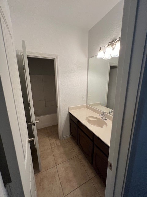 bathroom featuring vanity, a washtub, and tile patterned flooring