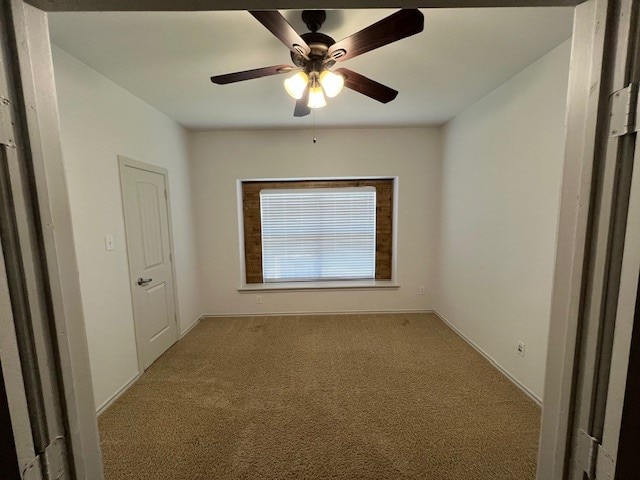 carpeted empty room featuring ceiling fan