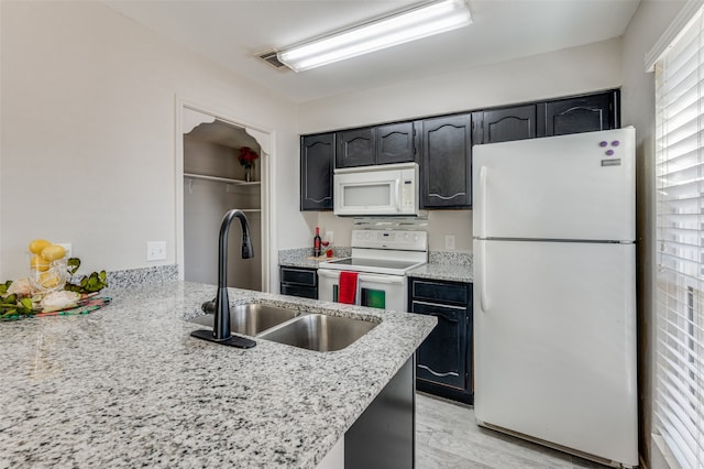 kitchen with sink, light hardwood / wood-style floors, and white appliances