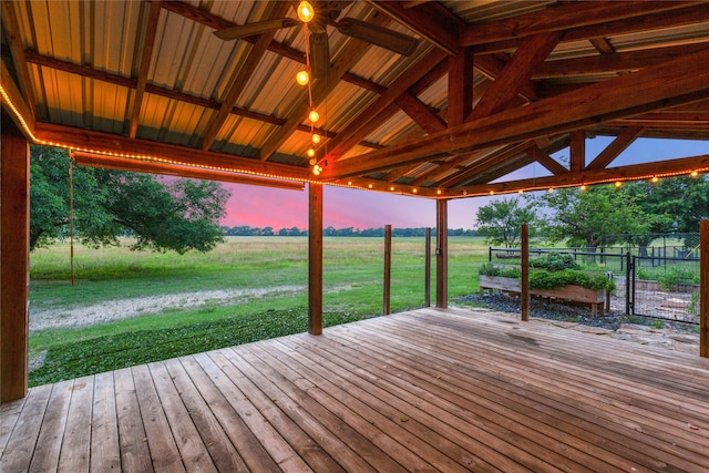 deck at dusk featuring a yard, a gazebo, and a rural view