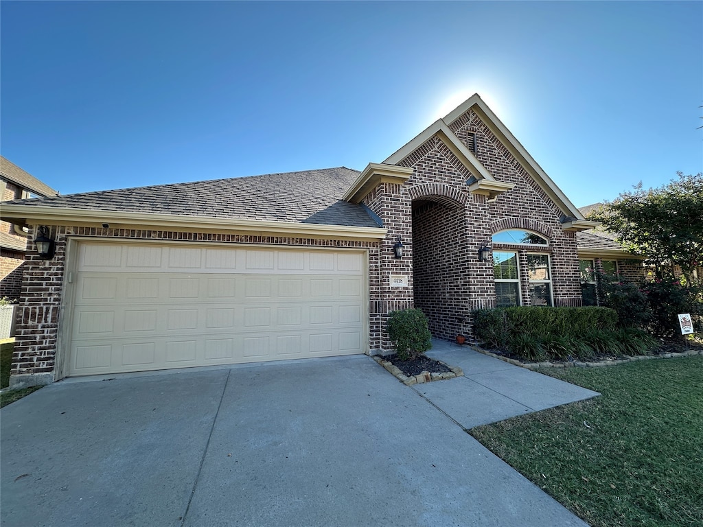 view of front of home with a front lawn and a garage