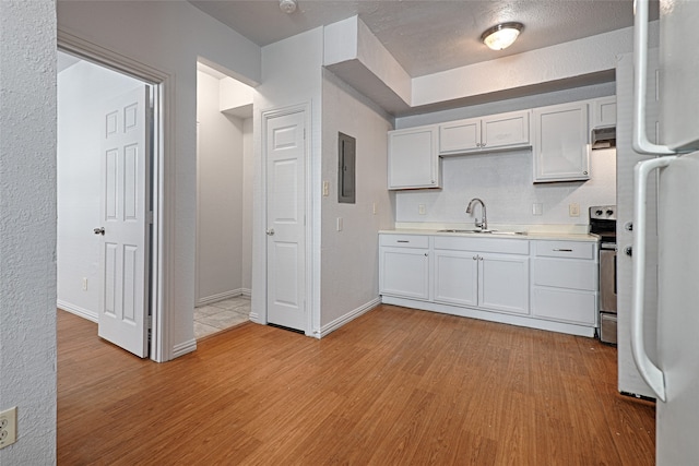 kitchen featuring white cabinetry, light hardwood / wood-style flooring, electric range, and sink