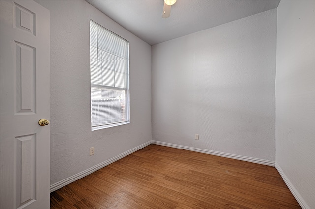 spare room with ceiling fan, hardwood / wood-style flooring, and a wealth of natural light