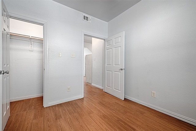 unfurnished bedroom with light hardwood / wood-style flooring and a closet