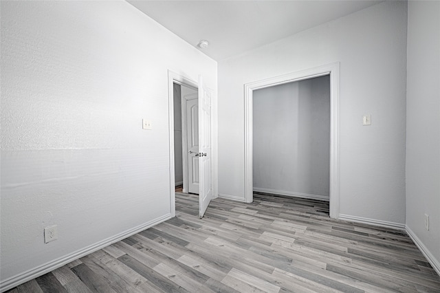 unfurnished bedroom with a closet and light hardwood / wood-style floors