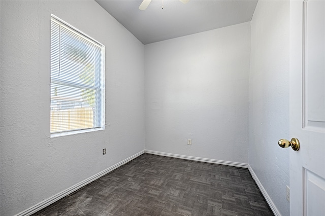 empty room with ceiling fan and dark parquet floors