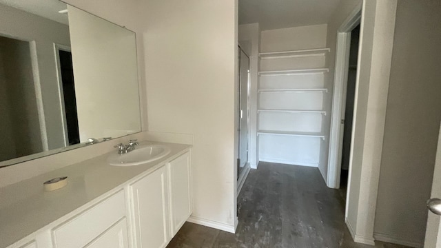 bathroom with walk in shower, hardwood / wood-style floors, and vanity