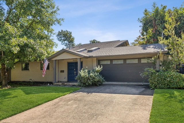 ranch-style house with a garage and a front lawn