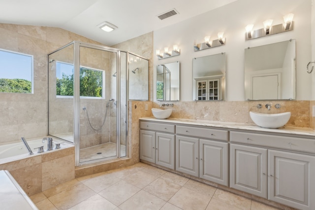 bathroom with separate shower and tub, tile patterned floors, vaulted ceiling, vanity, and tile walls