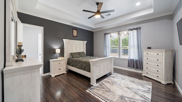 bedroom featuring ceiling fan, crown molding, a tray ceiling, and dark hardwood / wood-style flooring