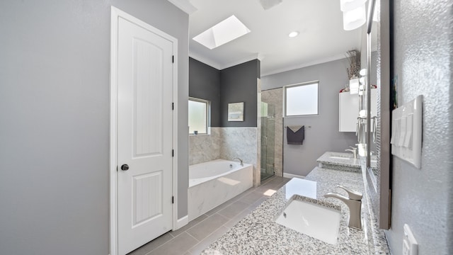 bathroom featuring separate shower and tub, ornamental molding, a skylight, vanity, and tile patterned floors