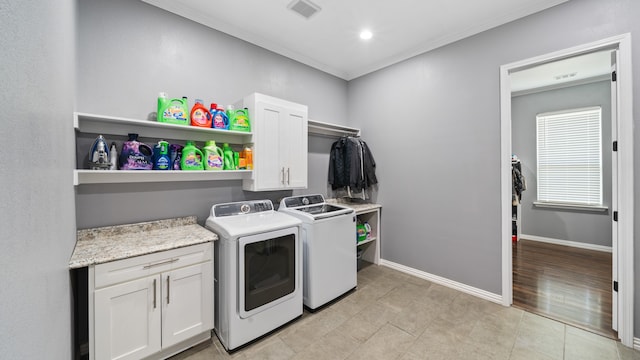 laundry room with cabinets, light hardwood / wood-style flooring, washer and dryer, and crown molding